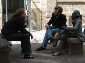 Two men and a statue discuss participation in visual anthropology