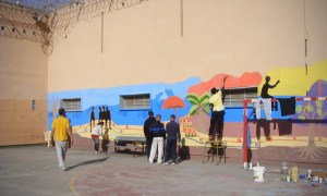 Prisoners painting a mural on their prison walls, 2012