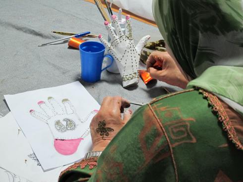 Working in henna during a painting workshop for women